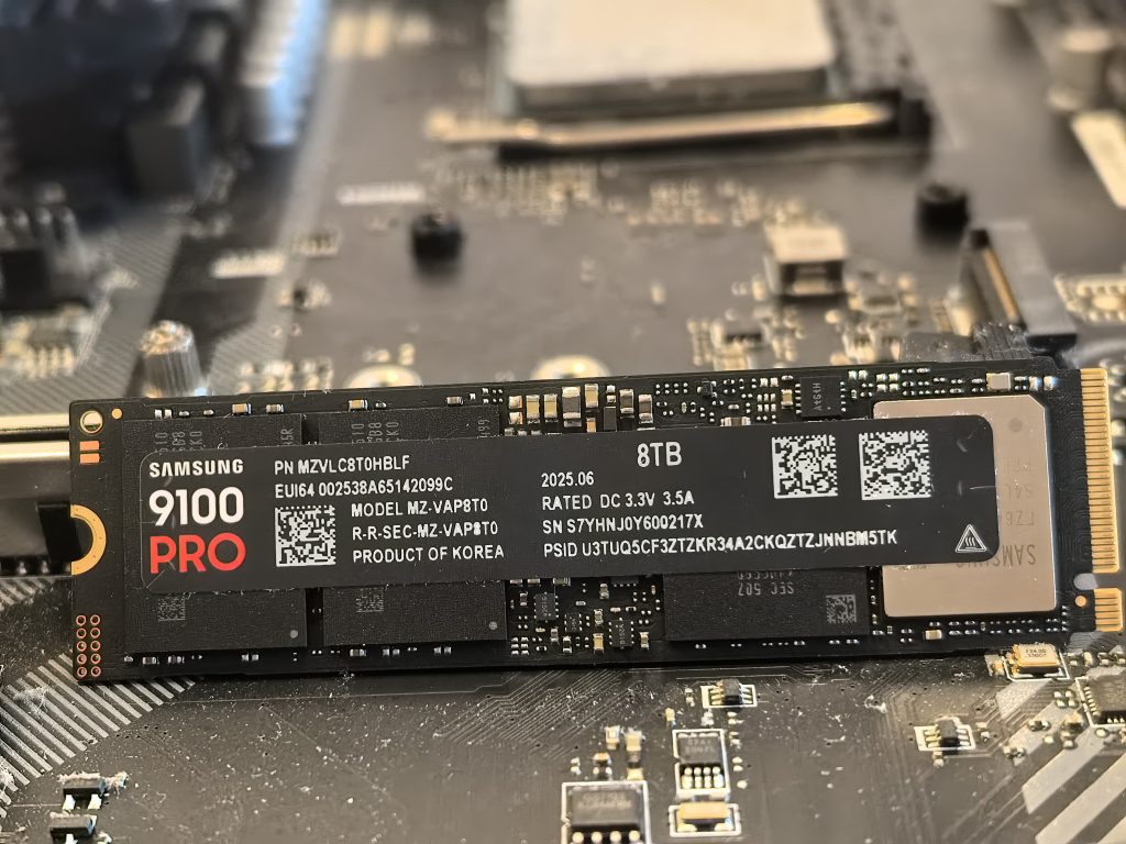 Samsung 9100 Pro 8 TB je dvostranski M.2 NVMe SSD. Na fotografiji je sprednja stran pogona s Samsungovim krmilnikom »Presto«, DRAM pomnilnikom in dvojnim nizom NAND čipov.